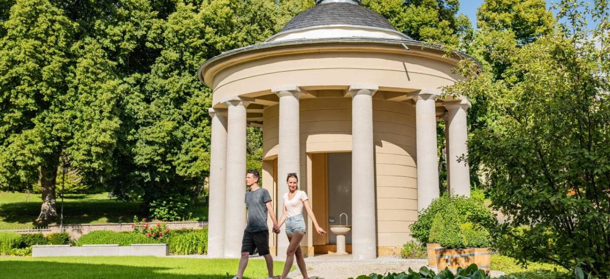 Landschaftsaufnahme mit Brunnentempel und Heilwasserbrunnen