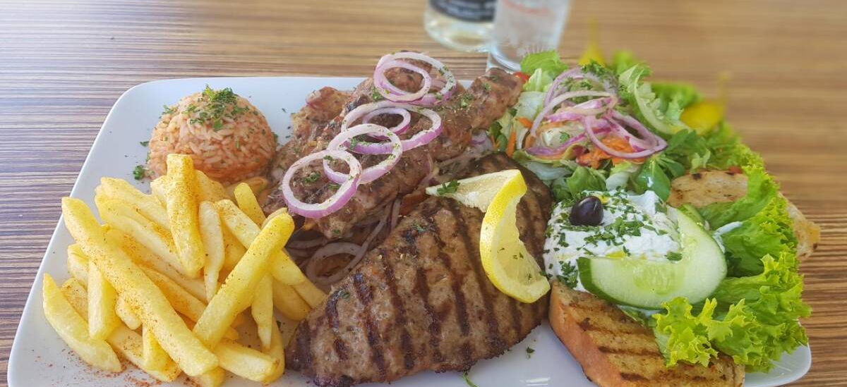 Speisenteller Restaurant Irodion mit Fleisch, Pommes, Salatbeilage und Reis