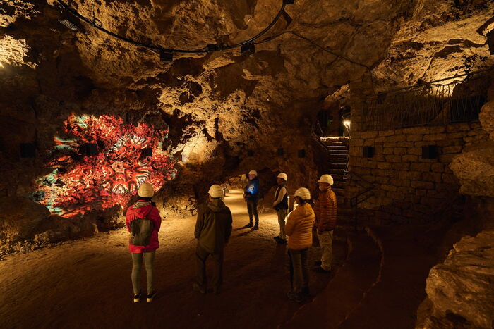 Besuchergruppe steht im Höhlendom und bestaunt die 3D-Installation